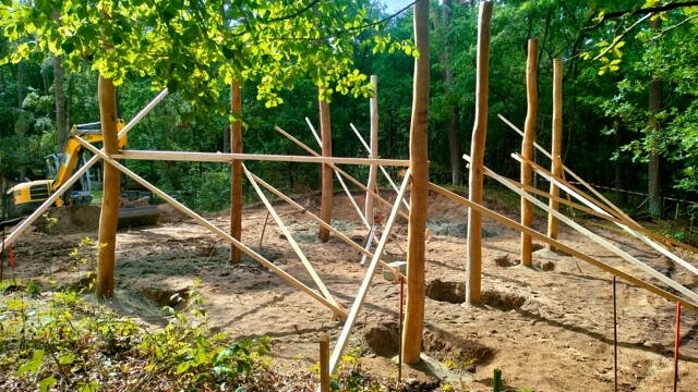 Neue Holzpfosten und Bagger auf der Baustelle des Waldspielplatzes Klövensteen in Hamburg-Rissen